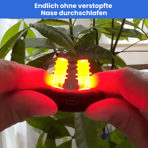 NasalPro wird in der Hand gehalten. Er leuchtet rot und im Hintergrund ist eine Pflanze zu sehen. Überschrift: Endlich ohne verstopfte Nase durchschlafen